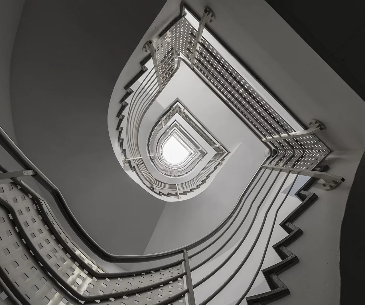 Senkrechter Blick nach oben in einem Treppenhaus mit asymmetrischem Treppenverlauf
